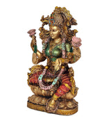 Lakshmi resin idol side view, gold ornaments, green blouse, red patterned sari, seated