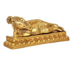 Brass reclining Ganesha on decorative platform base, detailed trunk and ornaments
