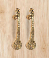 Brass sitar-shaped door handle pair with round rosette knobs and carved grip