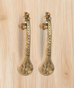 Brass sitar-shaped door handle pair with round rosette knobs and carved grip