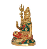 Brass Shiva statue side view, raised trident and colorful beaded belt and skirt