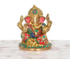 Gold brass Ganesha murti with red, teal and green gemstone-style accents and ornate base