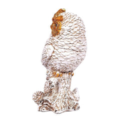 Side view owl figurine, cream feathers with brown head markings, on rocky base