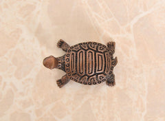 Copper tortoise figurine, top-down view of patterned shell and four legs
