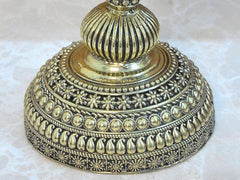Brass oil lamp diya base with beaded rim and floral engraving, close-up