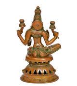 Lakshmi statue rear view with green-gold detailing, seated on lotus base, brass-tone