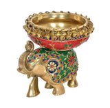 Brass elephant idol holding a large gold urli bowl, ornate red green jewels