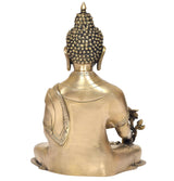 Rear view brass Buddha statue seated on pedestal, dark beaded halo
