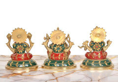 Back view of brass idols: multicolor skirts and gold fan-like halos on round bases.