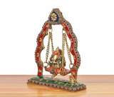 Brass Ganesha swing jhula statue, side view with multicolor arch, hanging chains