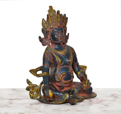 Three-quarter view of Kuber brass statue with detailed crown and gold accents
