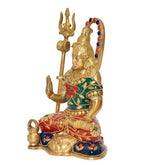 Brass Lord Shiva idol, side view, raised trident, arched halo, ornate jewelry