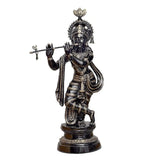 Brass Krishna statue with flute, standing on dark pedestal