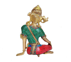 Side view of Indra Dev brass idol seated, green robe over red patterned base