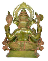 Back view of brass Ganesha sitting idol, green-gold finish with decorative halo arch