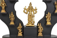 Close view of golden Lord Vishnu statue with hanging bell, surrounded by brass figures
