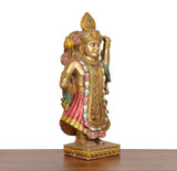 Resin Shreenathji murti three-quarter view, pink skirt, gold ornaments, green drape
