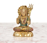 Brass Lord Shiva figurine seated cross-legged, raised trident and ornate face