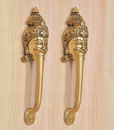 Close-up of golden brass long-neck door handles with detailed face head designs