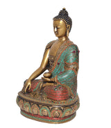 Brass meditating Buddha statue, side view; turquoise and red robe with jeweled details