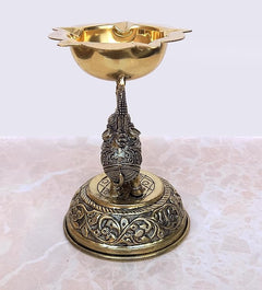 Detailed brass elephant diya with flared bowl and intricate engraved base