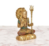 Brass Lord Shiva statue seated, profile face, trident raised, colorful ornaments