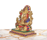 Side view of seated Lord Ganesha brass idol with multicolor tiled backrest