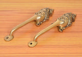 Golden brass long-neck door handles with curved levers and round mounting plates