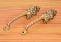 Golden brass long-neck door handles with curved levers and round mounting plates