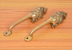 Golden brass long-neck door handles with curved levers and round mounting plates