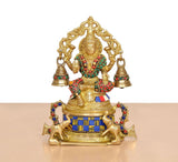 Brass Lakshmi statue front view, seated with four bells and jeweled multicolor accents