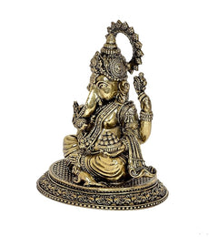 Brass Ganesha idol statue in profile, seated with ornate jewelry and halo