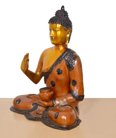 Brass Buddha idol side view, seated with Abhaya Mudra gesture and pot in lap