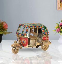 Brass auto rickshaw showpiece with green jewel-trim canopy, red side panels, flower details