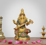 Brass Saraswati statue with jeweled detailing, seated, holding a veena for pooja