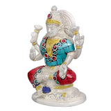 Close-up brass Ganesha idol with jeweled crown, turquoise tunic, red sash, raised hands