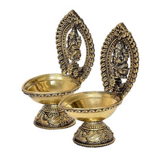 Brass oil lamp pair with Lakshmi and Ganesha idols in ornate oval frames