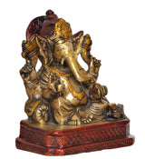 Brass Ganesh statue angled view, red halo, gold ornaments, patterned red base