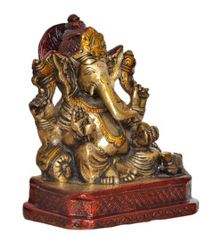 Brass Ganesh statue angled view, red halo, gold ornaments, patterned red base