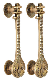 Golden brass door handles with round backplates, fluted stems and carved teardrops