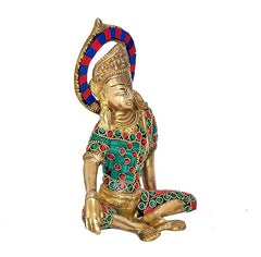Profile view of Indra Dev brass murti, seated with blue-red halo and green-red jeweled dress