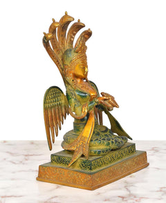 Brass naga kanya statue, angled view: gold crown, blue-green dress, seated on decorated base