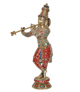 Brass Krishna idol playing flute, side view, red-and-green embroidered robe, ornate crown