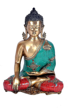 Brass Buddha idol front view, turquoise shawl over red patterned lap, gold face