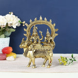 Brass Shiva Parvati idol seated on Nandi, ornate arch and crowns