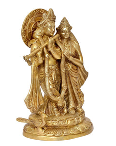 Brass Radha Krishna idol standing close together, intricate jewelry and carvings