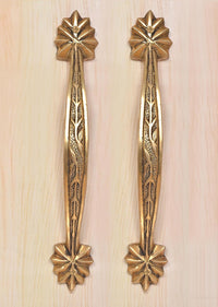 Brass main door handle pair on light wood, vertical leaf engraving with top and bottom rosettes.