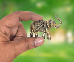 AONA 2-inch brass elephant figurine with ornate patterned saddle and raised curled trunk