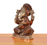 Brass Ganpati Bappa murti, side view; raised arms, beaded jewelry, ornate brass base.