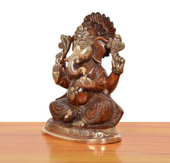Brass Ganpati Bappa murti, side view; raised arms, beaded jewelry, ornate brass base.